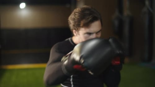 Aggressive sport man practicing boxing blows at gym fitness center workout