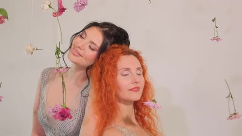 Two Beautiful Women Posing with Flowers