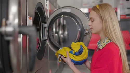 Woman Taking Clothes Out Of Washing Machine