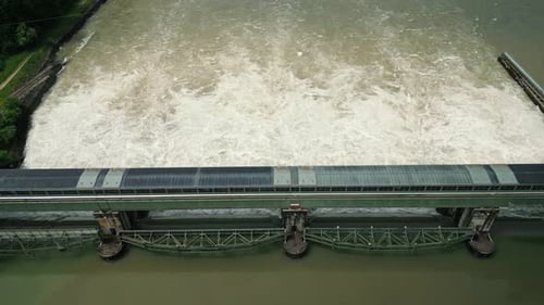 Top view of huge water stream falling down from open gates at water dam