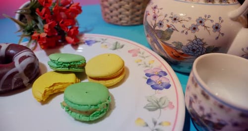 Assorted Macarons and Donut Displayed on Floral Plate
