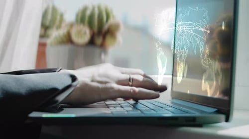 Nahaufnahme einer Frau im Anzug, die ihren Laptop für Cyberangriffe benutzt Hologramm von Cyberangriffen auf der Weltkarte