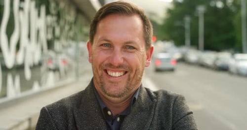 Retrato de empresário maduro sorridente sozinho em uma movimentada cidade urbana