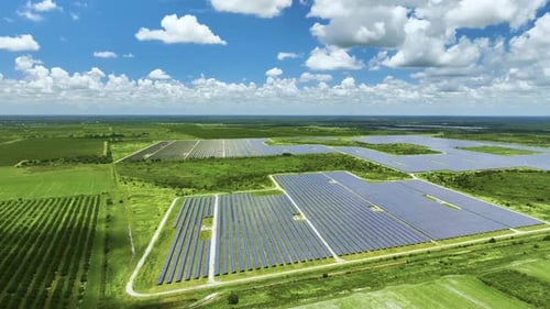 Aerial View of Sustainable Electrical Power Plant Between Agricultural Farmlands with Photovoltaic