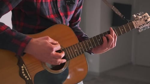Man Playing Acoustic Guitar Indoors Close Up