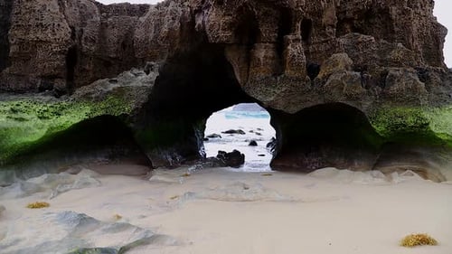 Natural Geology rock islet cave tunnel caused by sea erosion on sandy beach on the Porto Santo islan