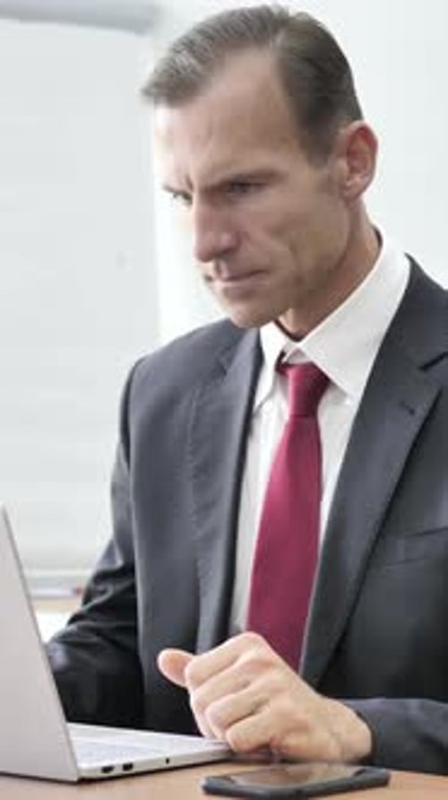 Upset Man Frustrated with Computer in Office Workplace