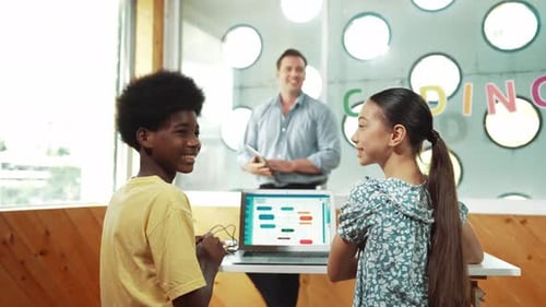 Los
alumnos estudian el sistema de programación mientras se dan la vuelta para mirar a la cámara. Edificación
