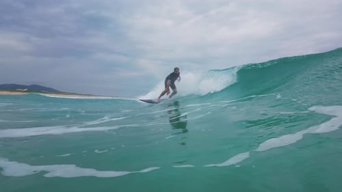 Surfer Rides Wave on a Cloudy Day
