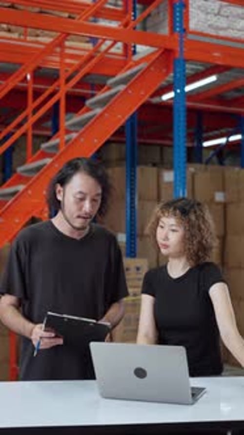 Two warehouse employees collaborating on inventory management