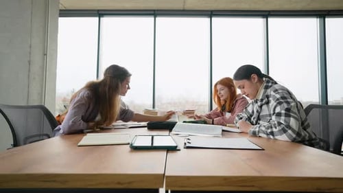 Happy Young University Students Studying with Books in Library