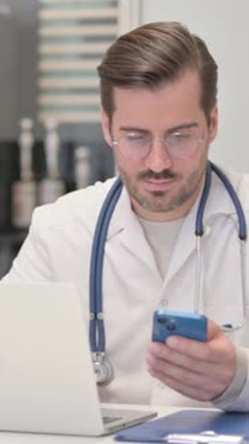 Young Doctor Talking on Phone in Clinic