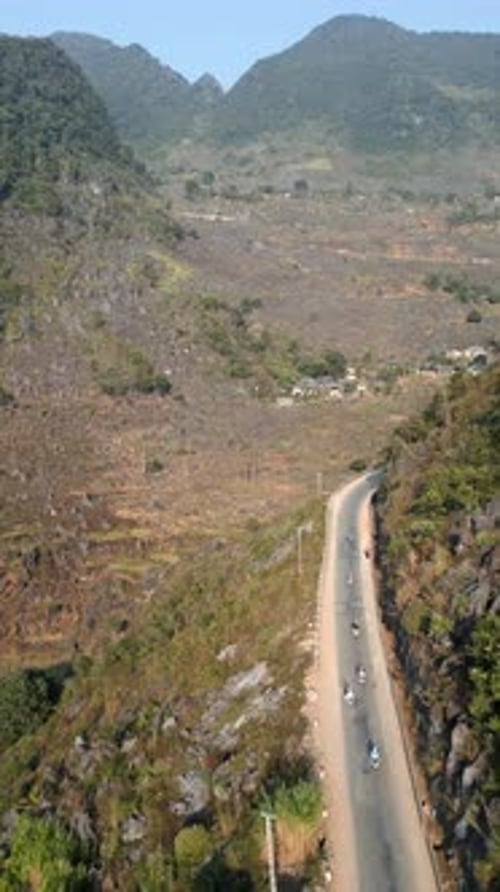 Aerial View of Motorbikes Riding Through Mountain Road in Ha Giang Vietnam