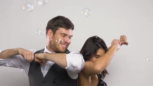 Happy young couple blowing bubbles together