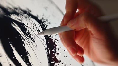 Woman hand painting on a graphic tablet with a white pen, close up