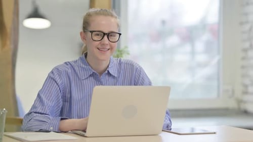Young Adult Woman Working on Laptop at Desk
