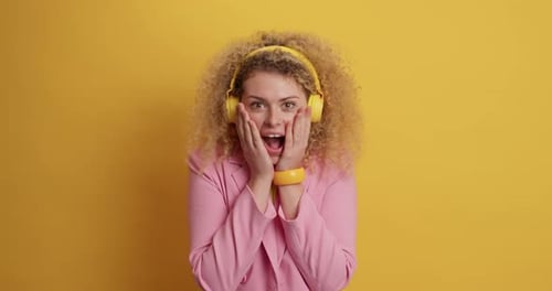 Excited Woman with Curly Hair Smiling with Headphones