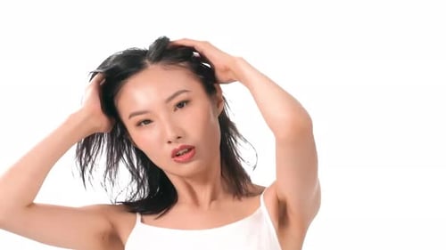 Happy girl professional make-up artist works in her make-up studio. She enjoys making up herself.