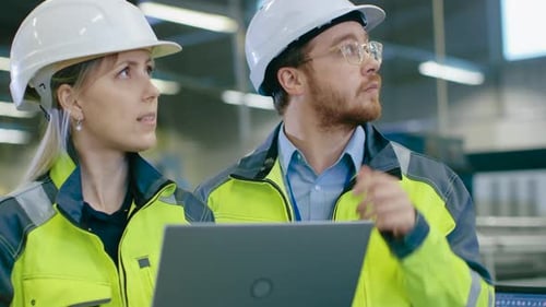 Male and Female Industrial Engineers Work on a Manufacturing Plant, They Discuss Project, Point in