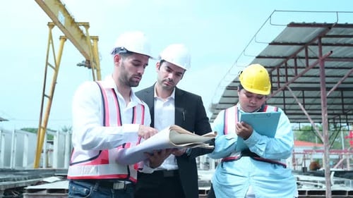 Group of architects, construction foremen, and construction engineers review the work