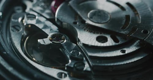 Slow motion close up of a professional watchmaker repairer working on a luxury mechanism watch gea