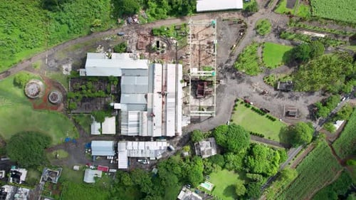 A sugar estate with factory amid lush greenery, aerial view