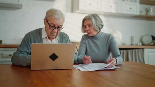 Portrait of Senior Married Couple Sitting at Home Kitchen Discussing Budget Elderly Man and Woman