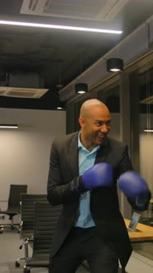 Vertical of Two Competitive Businessmen Fighting with Boxing Gloves in Corporate Office