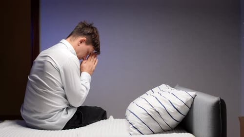 Young Man in White Shirt Praying Indoors