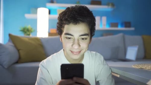 Teen Using Smartphone in Living Room at Night