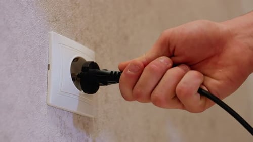 Brancher à la main un fil noir dans une prise murale