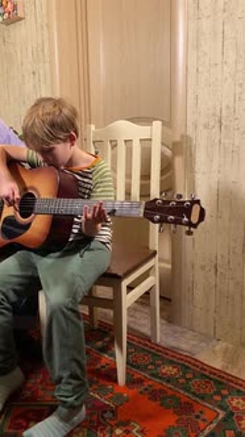 Boy Learning Guitar at Home with Instructor