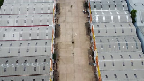 Aerial view of a goods distribution warehouse lined up with goods trucks parked in front of the ware