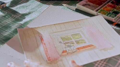 Artist gently applying detail to a water colour painting, painter at work, close up shot, creativity