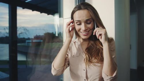 Attractive Woman Chatting on Phone Indoors By Window