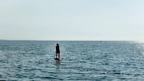 Man Paddle Boarding on Calm Ocean Water
