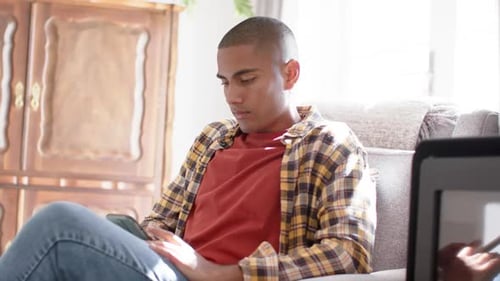 Happy biracial man using smartphone at home, slow motion