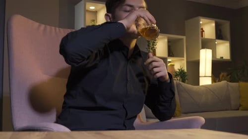 Stressed man drinking alcohol, whiskey.