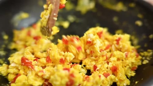 Scrambled Eggs with Red Pepper Being Stirred