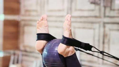 Woman Using Pilates Machine with Exercise Ball