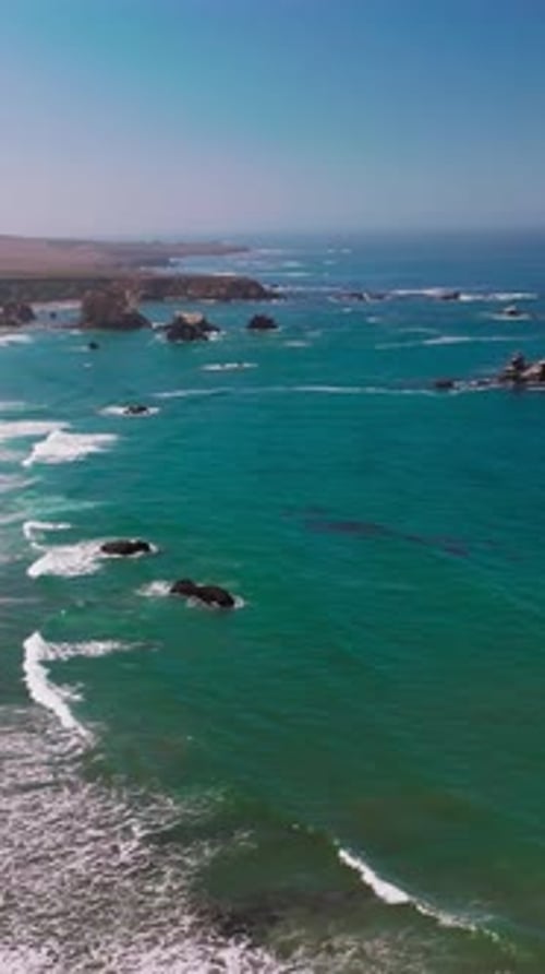 Amazing view of azure scenery of the ocean. Lovely sight of waves arriving to the rocky coastline