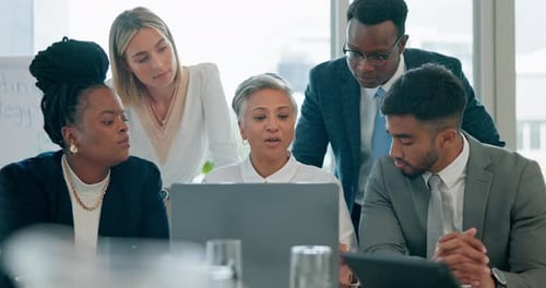 Diverse Team Collaborating Around Laptop in Modern Office