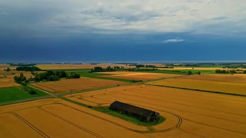 Foto aérea estática de uma calçada rural passando por campos agrícolas durante o dia. Rural