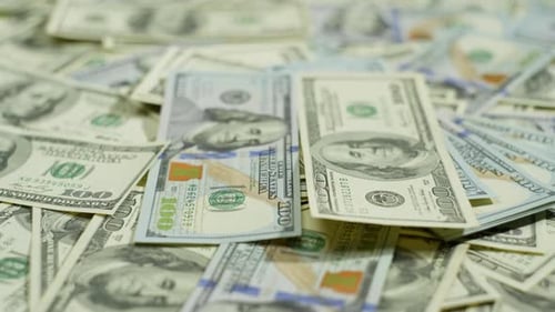 Los billetes de cien dólares viejos y nuevos están esparcidos sobre la mesa