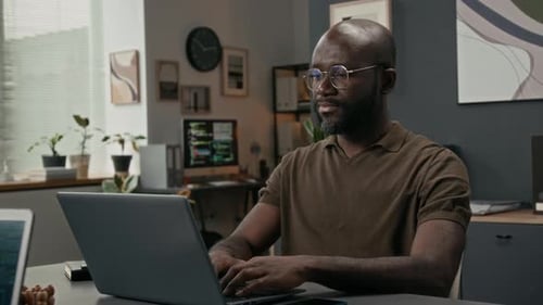 Portrait of Cheerful Programmer Coding on Laptop during Workday in IT Office