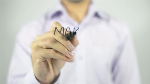 Man Writes 'Make More Money' on Transparent Surface