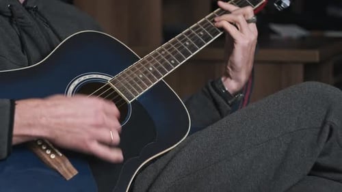Man Plays Acoustic Guitar Close-Up Indoors