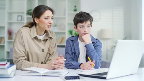 Mother and son watch an online lesson on a laptop computer. school child boy studying via internet