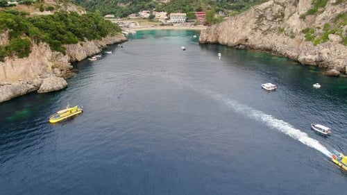 Aerial View of Boats Navigating the Narrow Entrance to Paleokastritsa Bay Surrounded by Steep Cliffs
