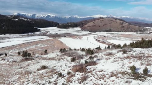 aerial view snow covered mountain fields and peaks on a sunny winter day
